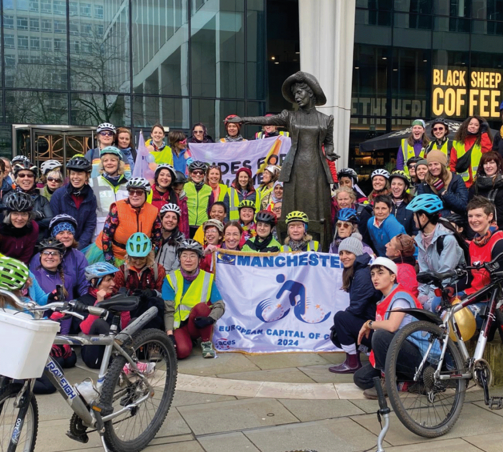 Many women posing with bikes