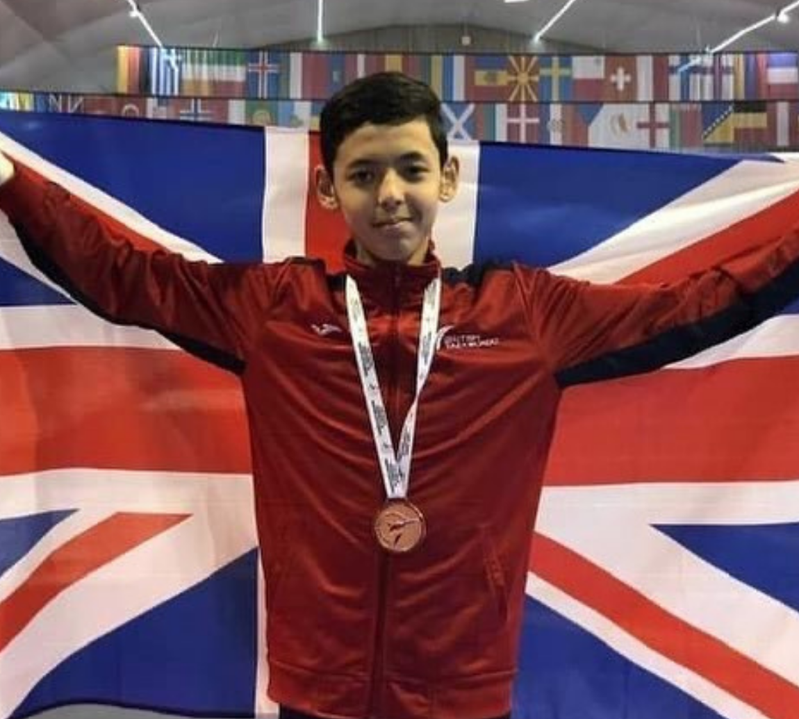 Image of a boy with a flag and a medal