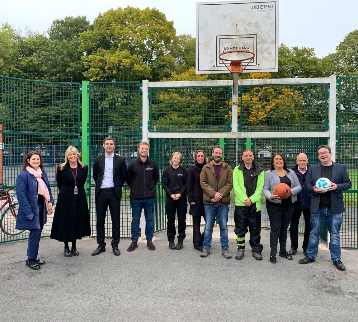 A group of people on a basketball court holding basketballs