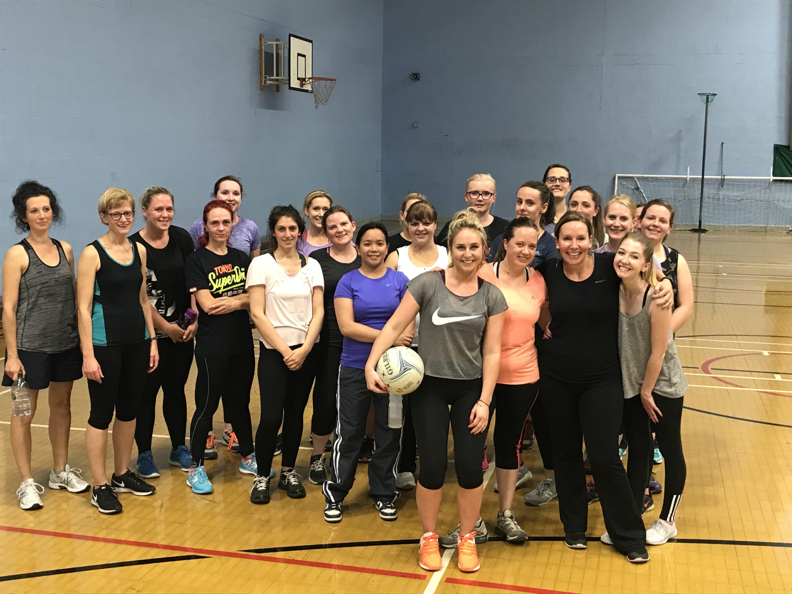 Group of women playing netball indoors