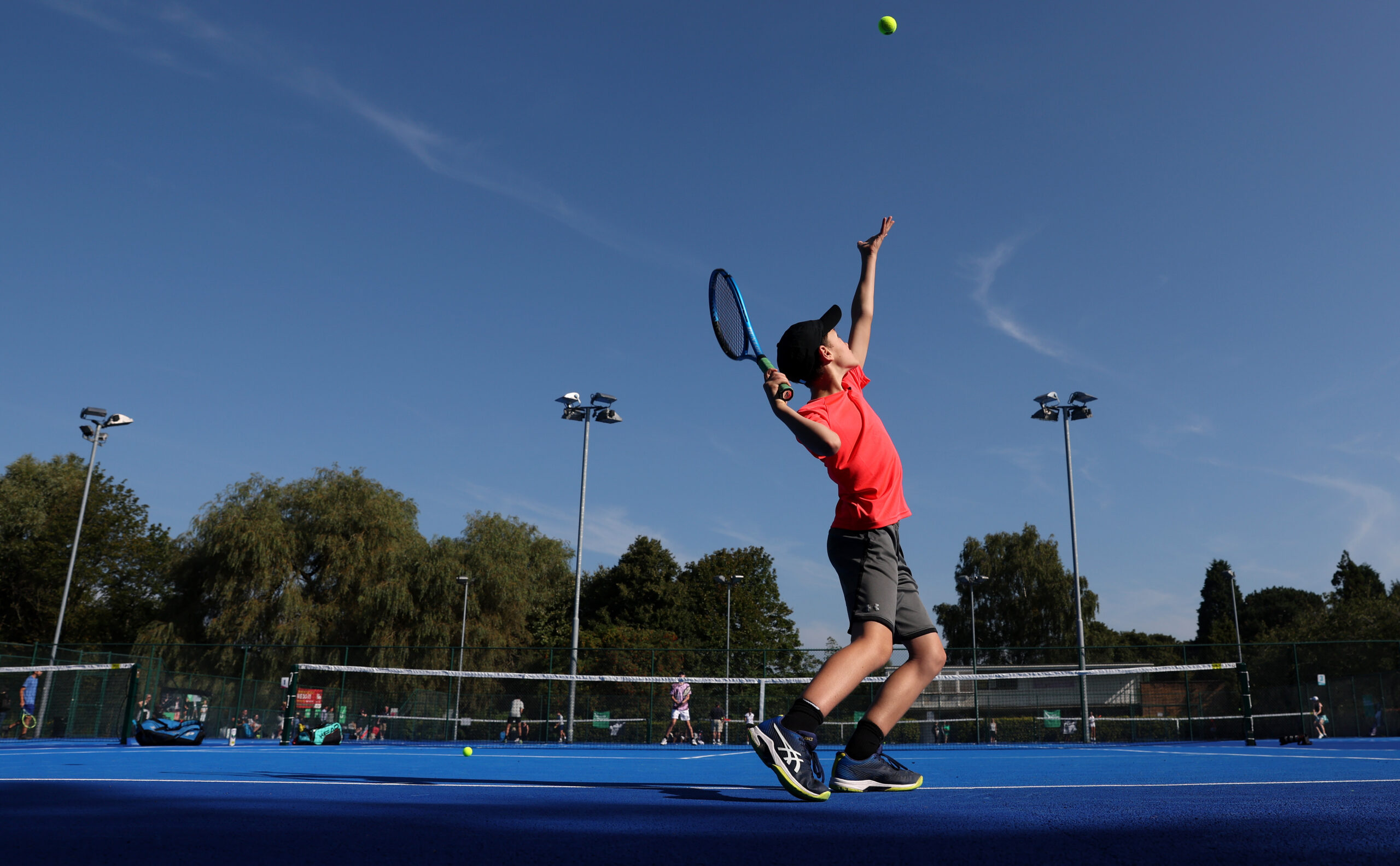 Child serving tennis