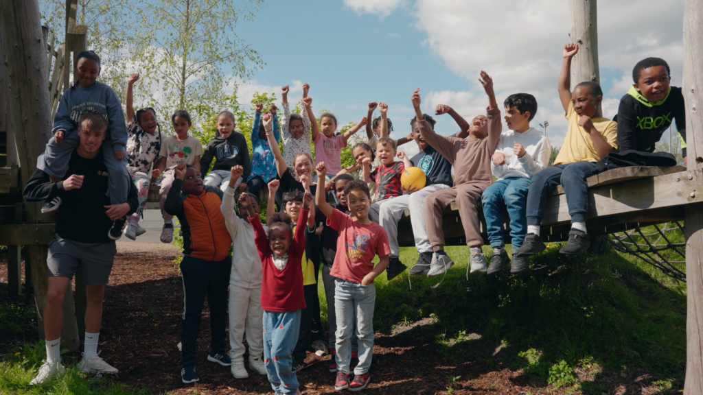 group of kids with arms in air at holiday camp
