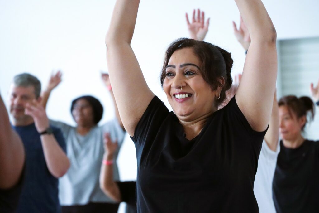 Female dance class - Woman with arms in the air smiling