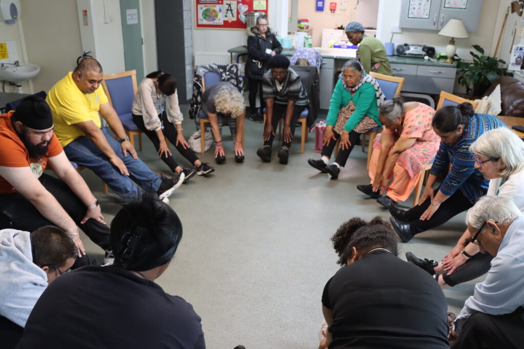 Group of people sat in circle doing chair based activities